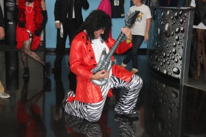 Person playing the guitar with people dancing in the background