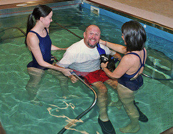 Two trainers helping person do Hydrotherapy at HydroWorx