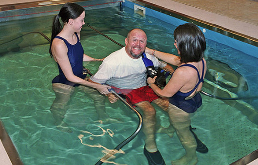 Two trainers helping person do Hydrotherapy at HydroWorx