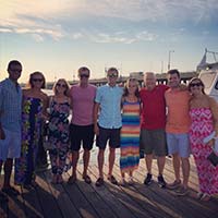 Group of people posing for photo at sunset