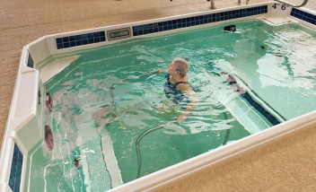 Person training on metal bars in HydroWorx pool