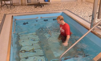 Person training in pool wearing Huskers shirt