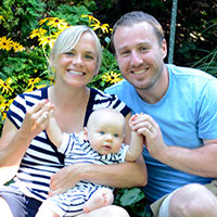 Two people holding a baby