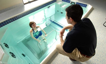 Trainer instructing trainee in pool