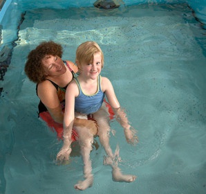 Person holding child in pool