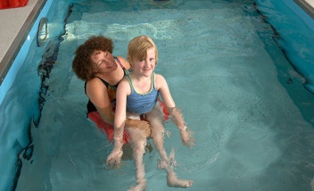 Person holding child in pool