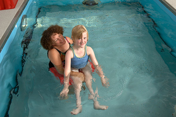 Person holding child in pool