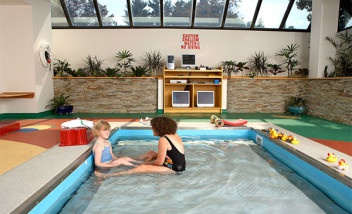 Person sitting with child in pool