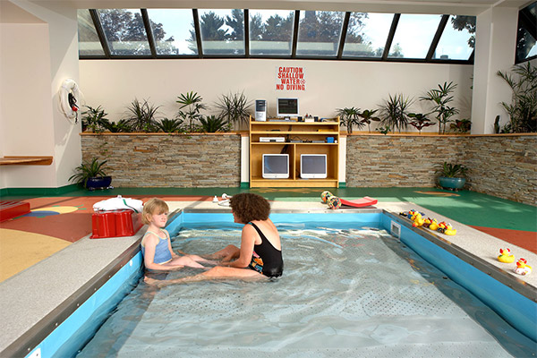 Person sitting with child in pool