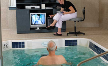 Trainer instrcuting Pool trainee with tv display