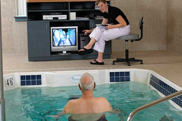 Trainer instrcuting Pool trainee with tv display