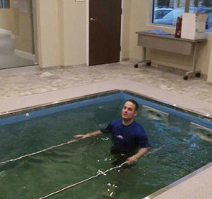 Person in HydroWorx pool with metal bars