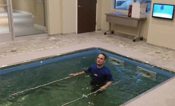 Person in HydroWorx pool with metal bars