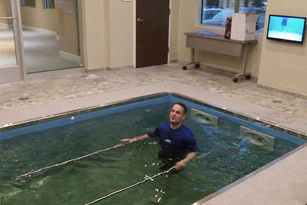 Person in HydroWorx pool with metal bars