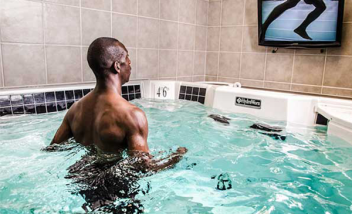 Person watching self run in pool on monitor
