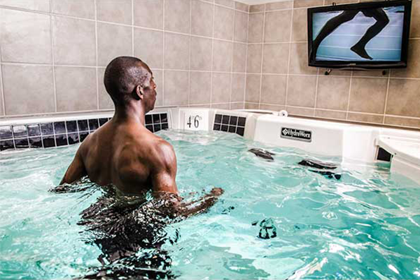Person watching self run in pool on monitor