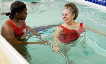 Lifeguard helping pool trainee