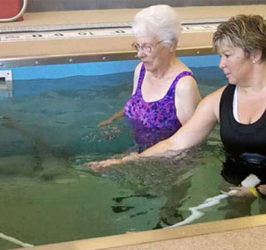 Two people using water massage hose