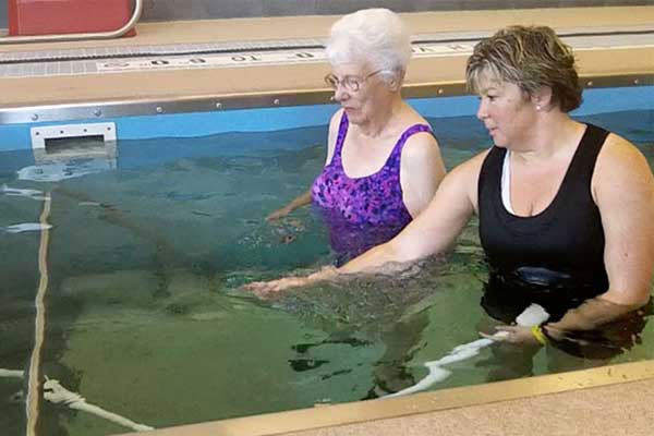 Two people using water massage hose