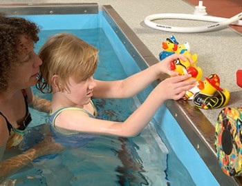 girl playing with toys in pool